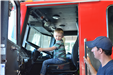 young boy sitting in driver's seat of fire truck
