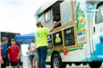 man waits in line at a food truck
