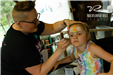 girl sitting at face painting station