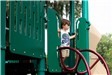 boy standing at top of playground slide