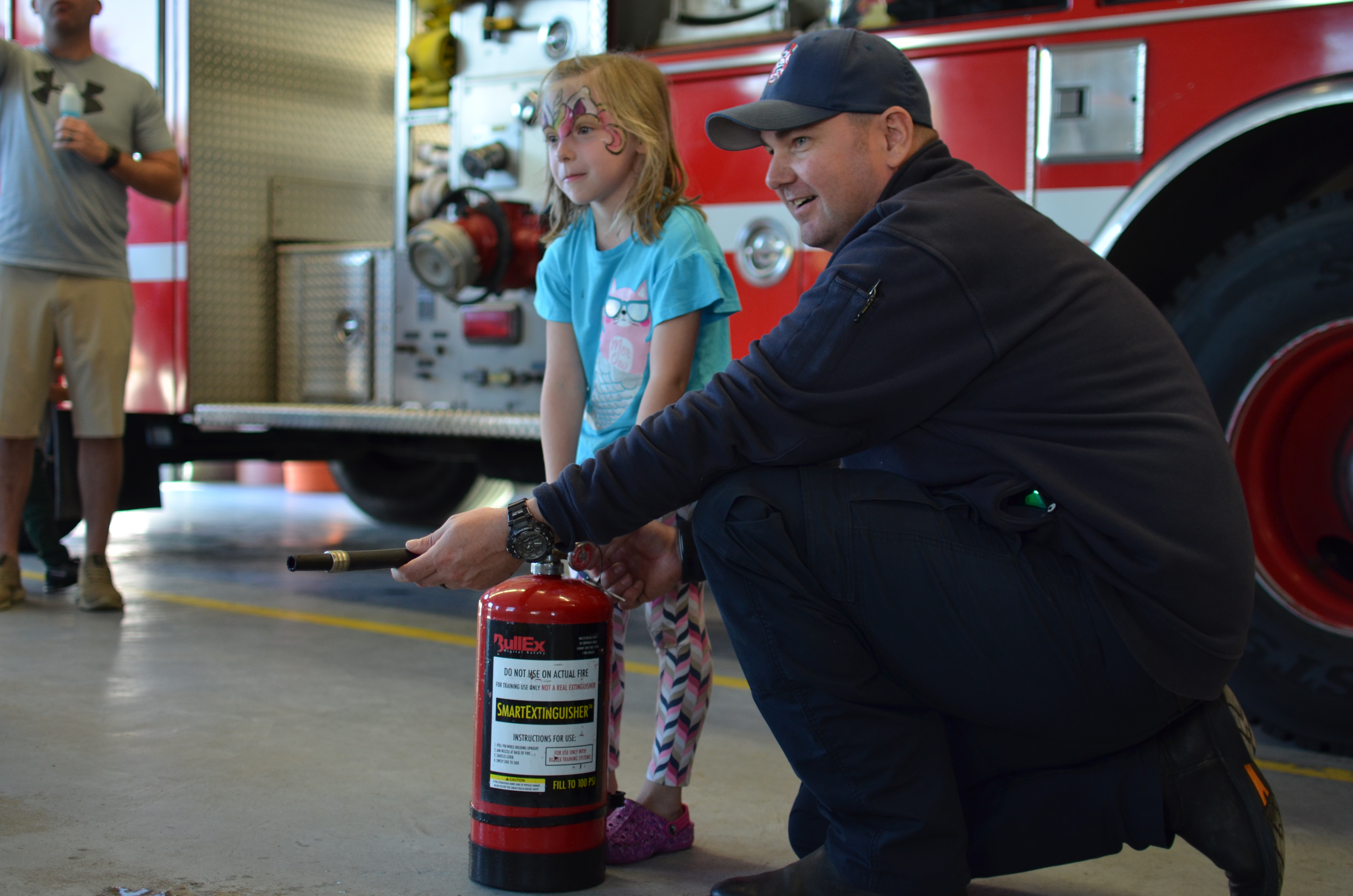 firefighter demonstrates use of fire extinguisher