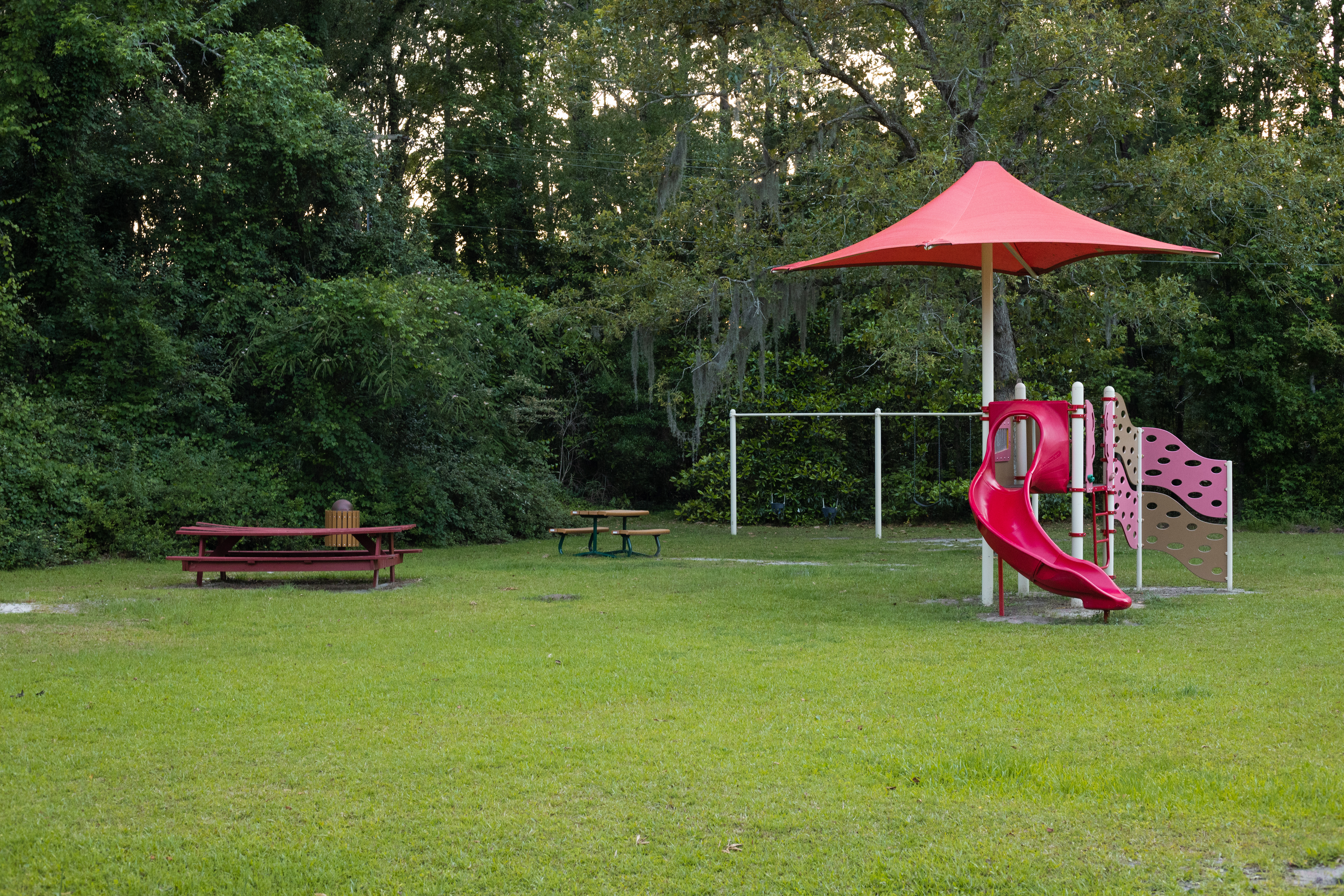 playground structure and red picnic tables