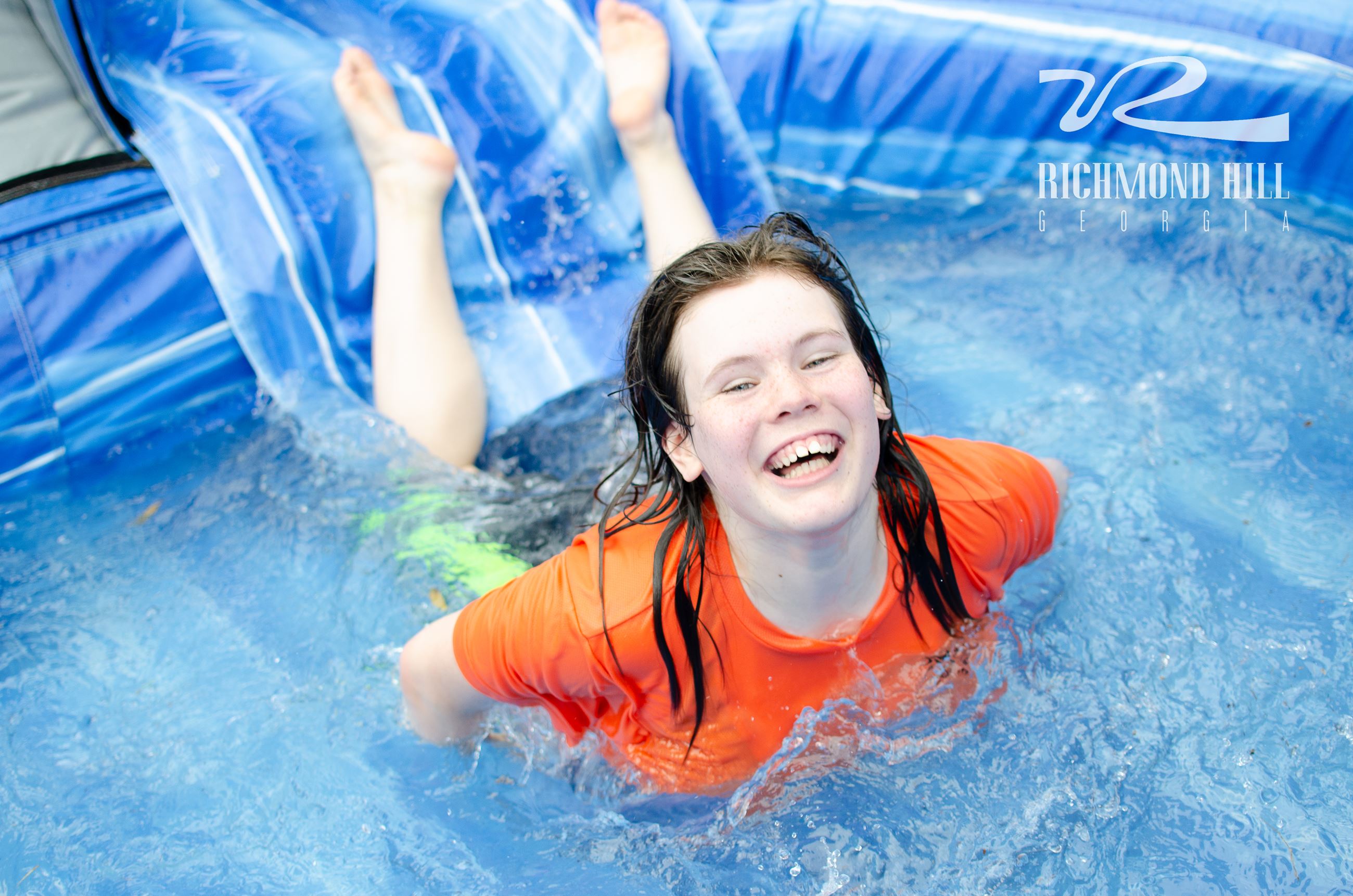girl reaches the bottom of a water slide