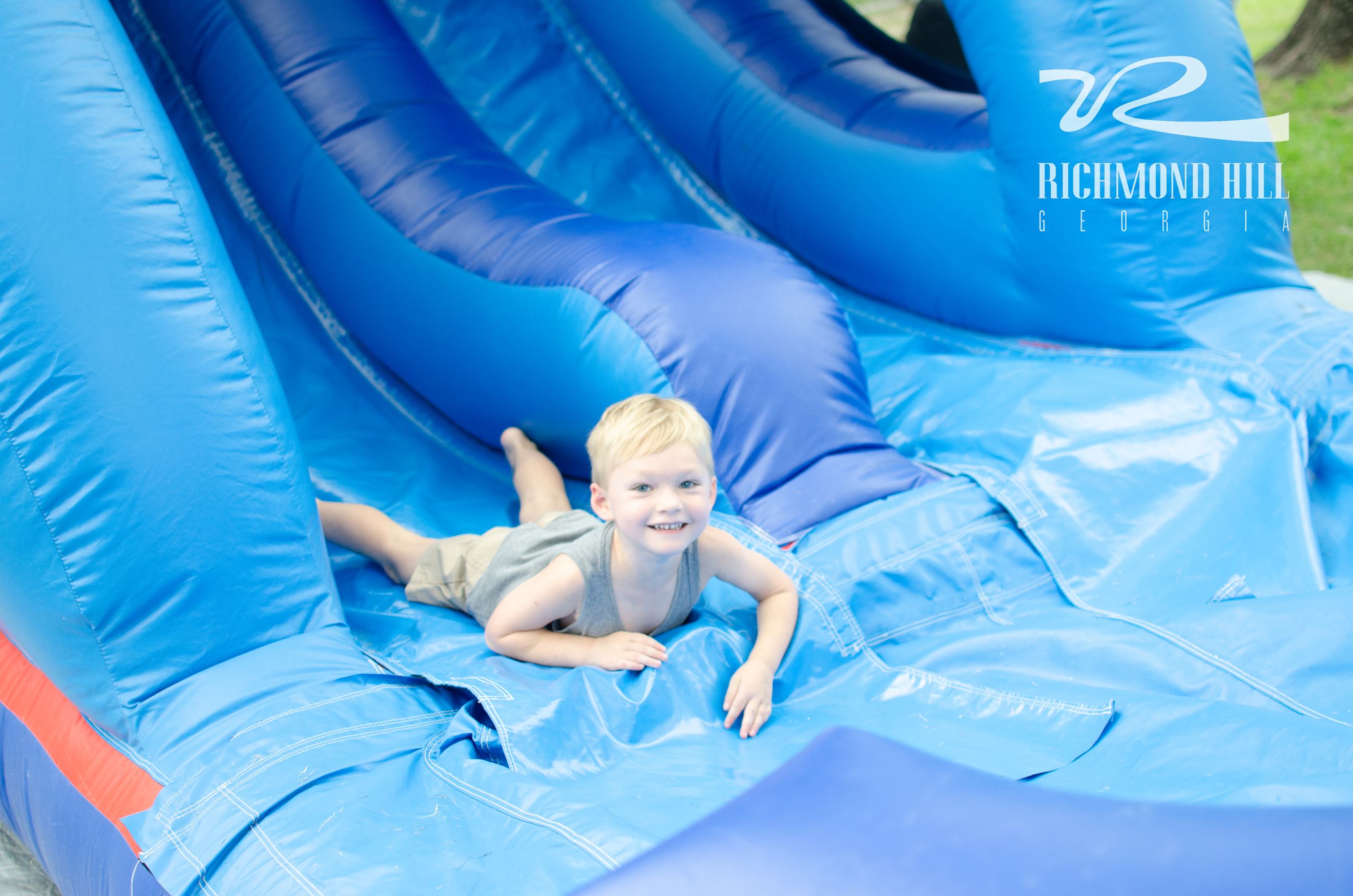 boy at the bottom of blue water slide