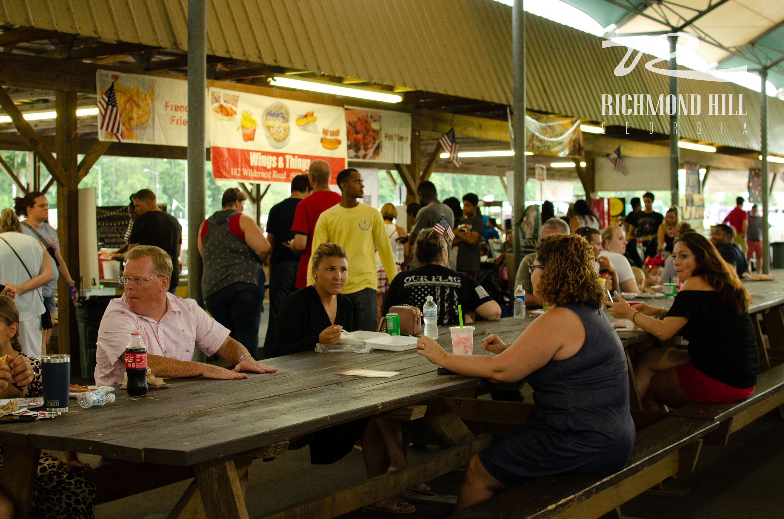 group of people sitting at a picnic table