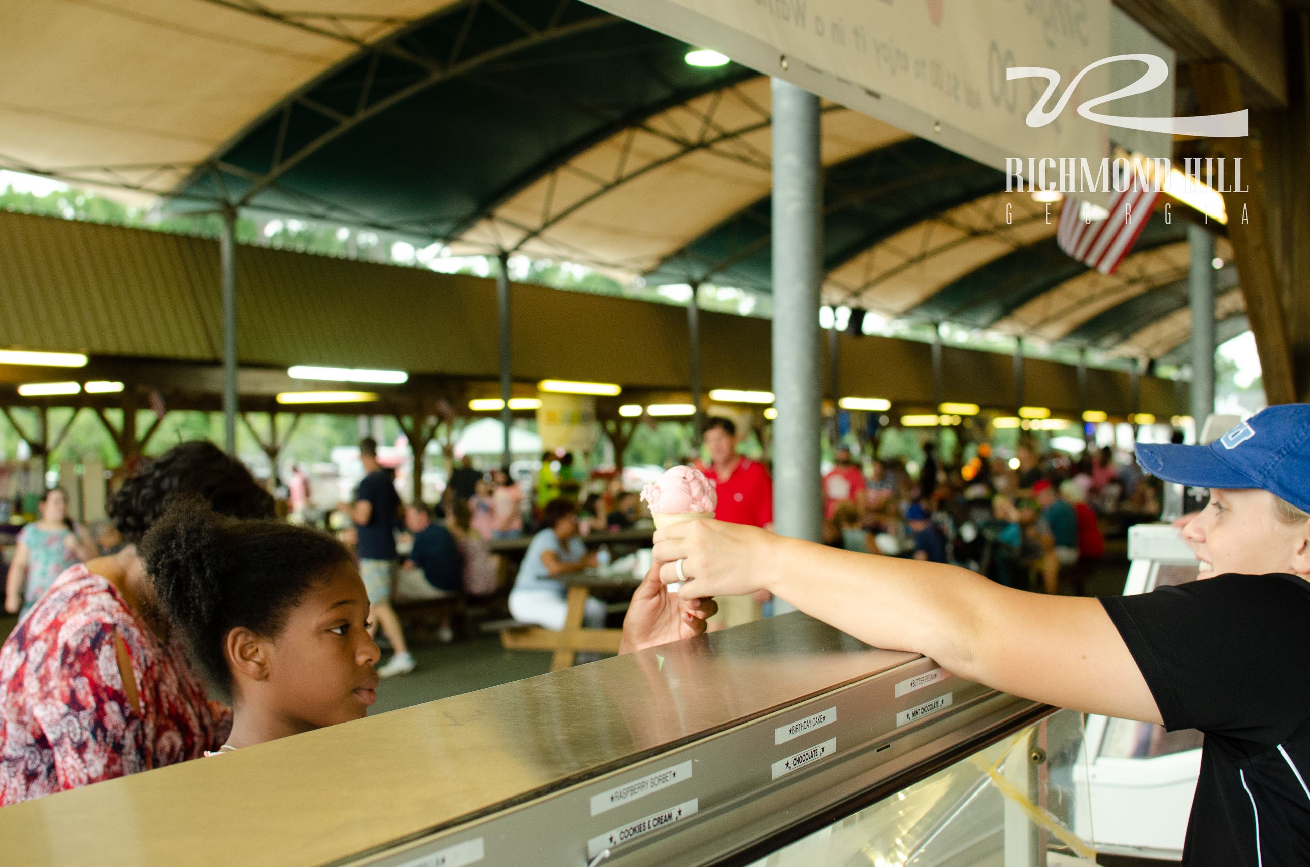 a girl takes a snow cone from a server