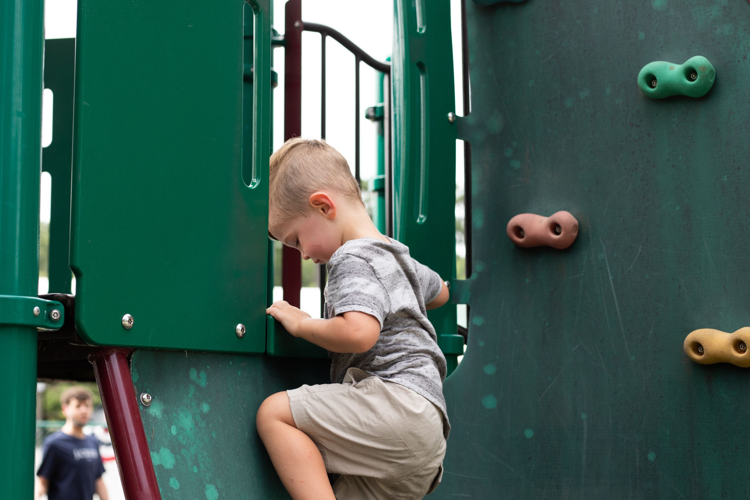 boy climbing on rock wall
