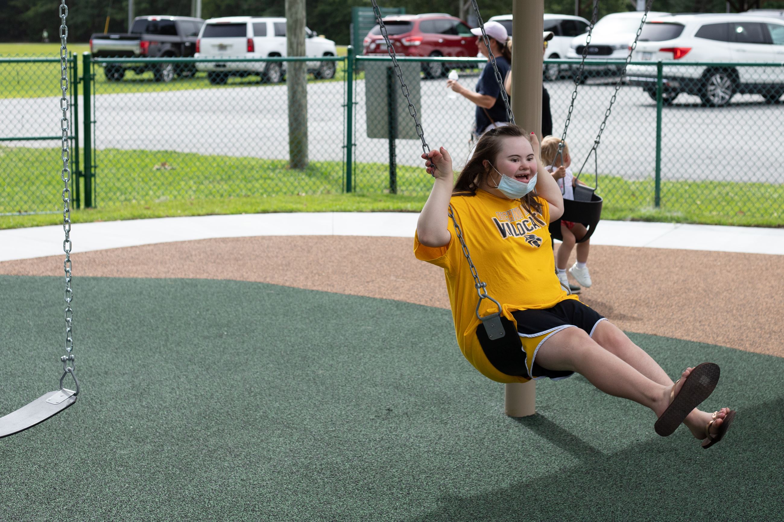 girl swinging under shaded park swings